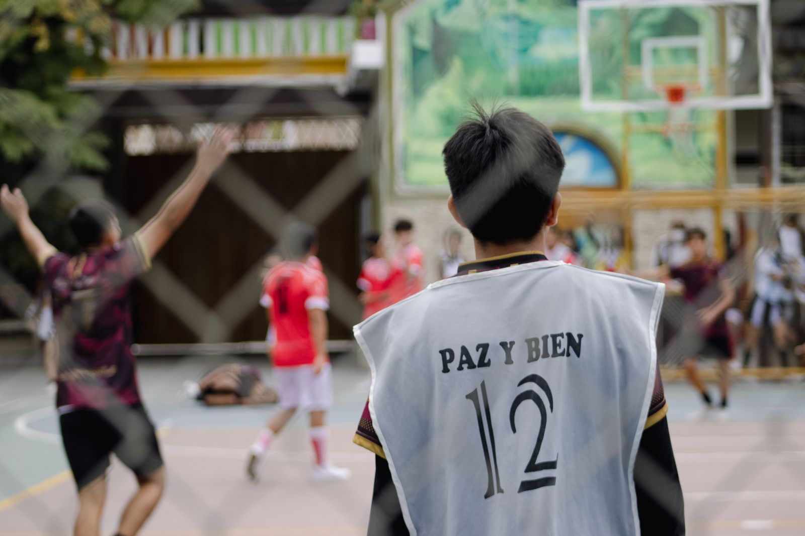 Pemain basket muda berjersey tim bermain di lapangan terbuka