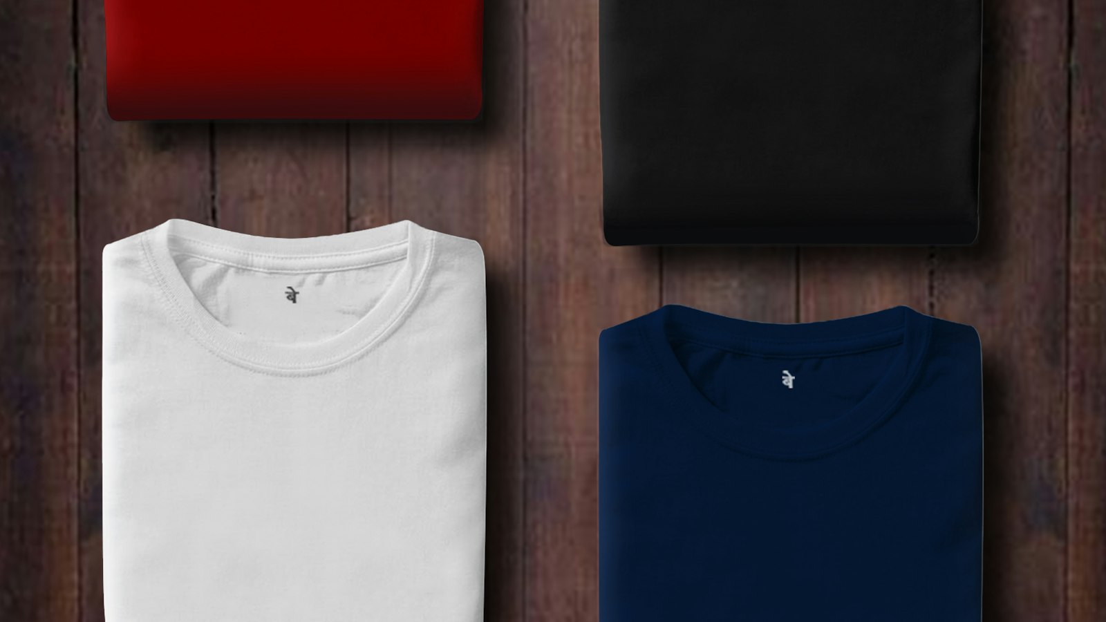 Tumpukan kaos berwarna terlipat rapi di atas rak kayu